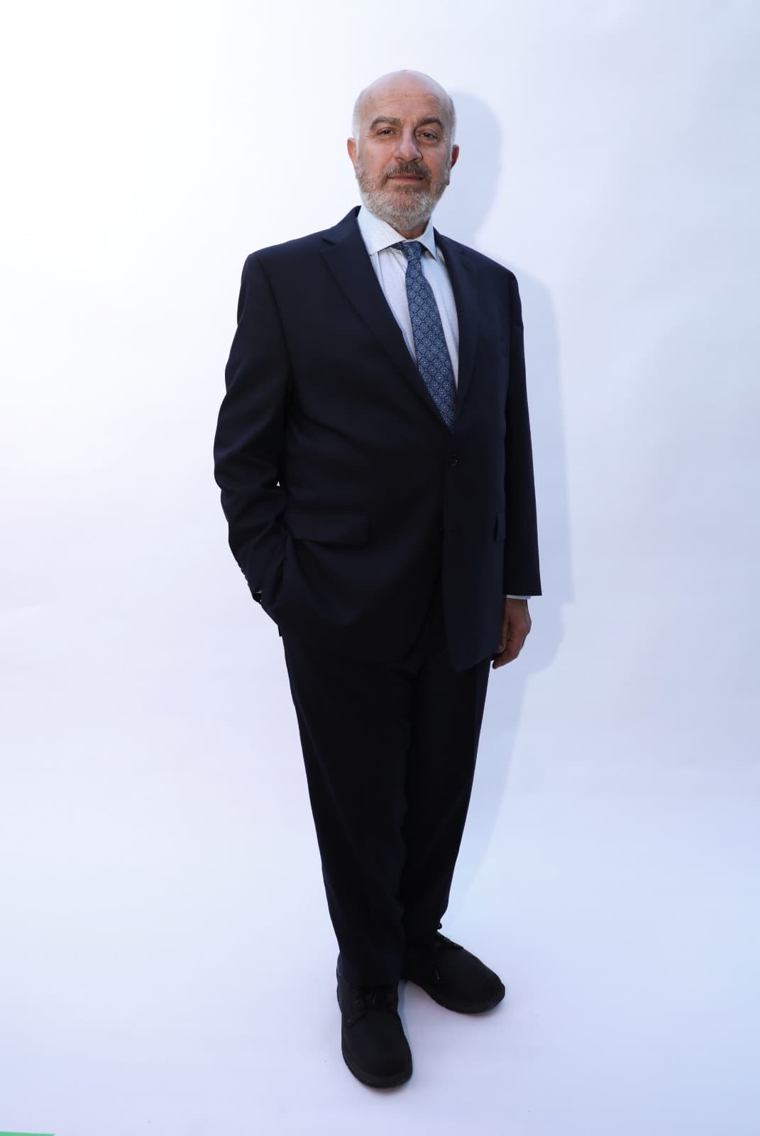 Full-length portrait of Serge Khatchadourian in a dark navy suit
