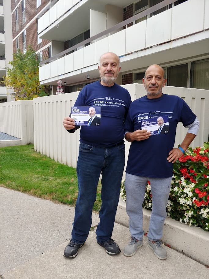 Serge Khatchadourian and a volunteer holding campaign flyers outside a Scarborough apartment