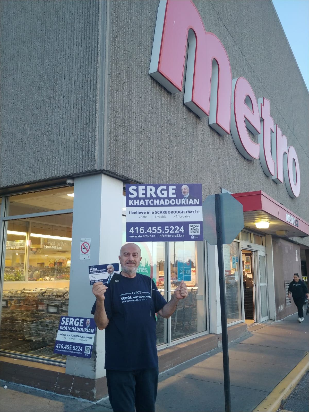 Serge Khatchadourian with campaign signs outside a Metro grocery store in Scarborough