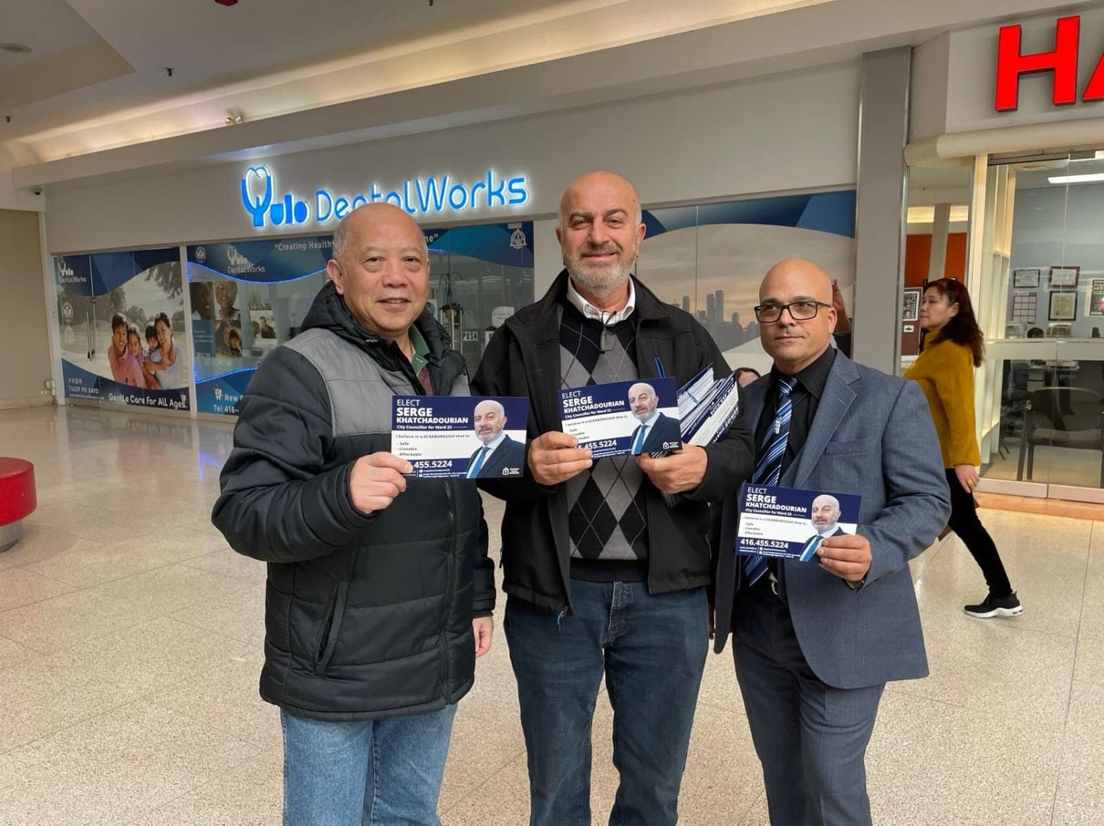 Serge Khatchadourian with supporters holding campaign flyers inside a Scarborough mall